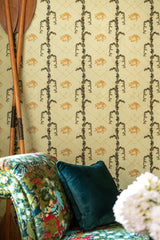 Close-up of yellow wallpaper with vertical green vines and orange fish motifs, wooden oars, and a floral patterned chaise lounge