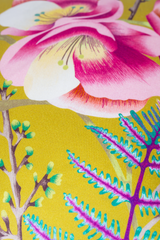 Close-up of a colorful floral design with pink flowers and green leaves on a chartreuse background.