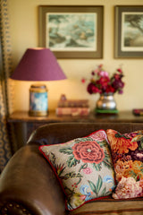 Photo of a brown leather sofa with floral cushions