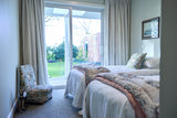 Photo of a twin bedroom with vintage bedspreads, chair and floral cushion
