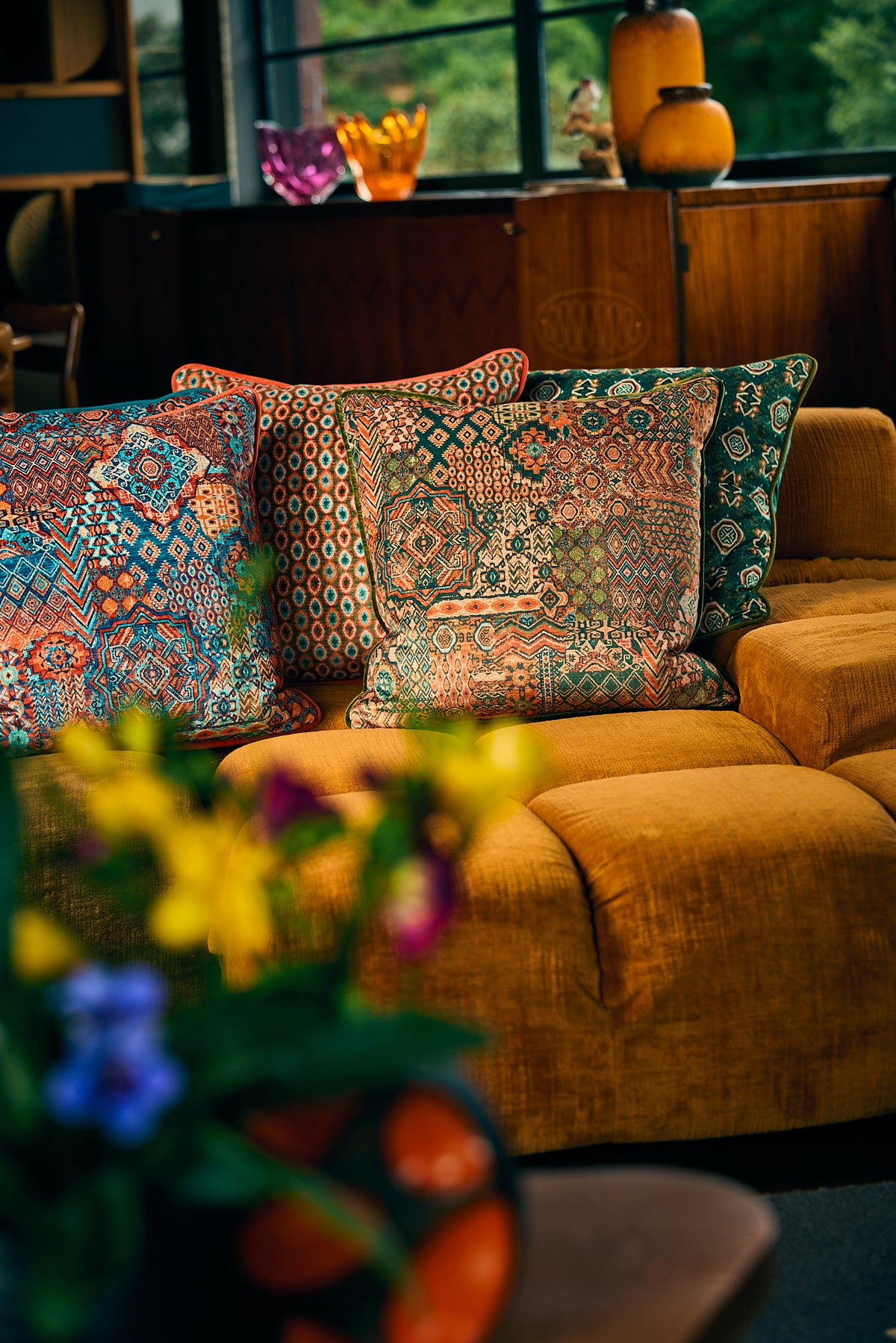 Cosy lounge scene with patterned cushions on a gold sofa