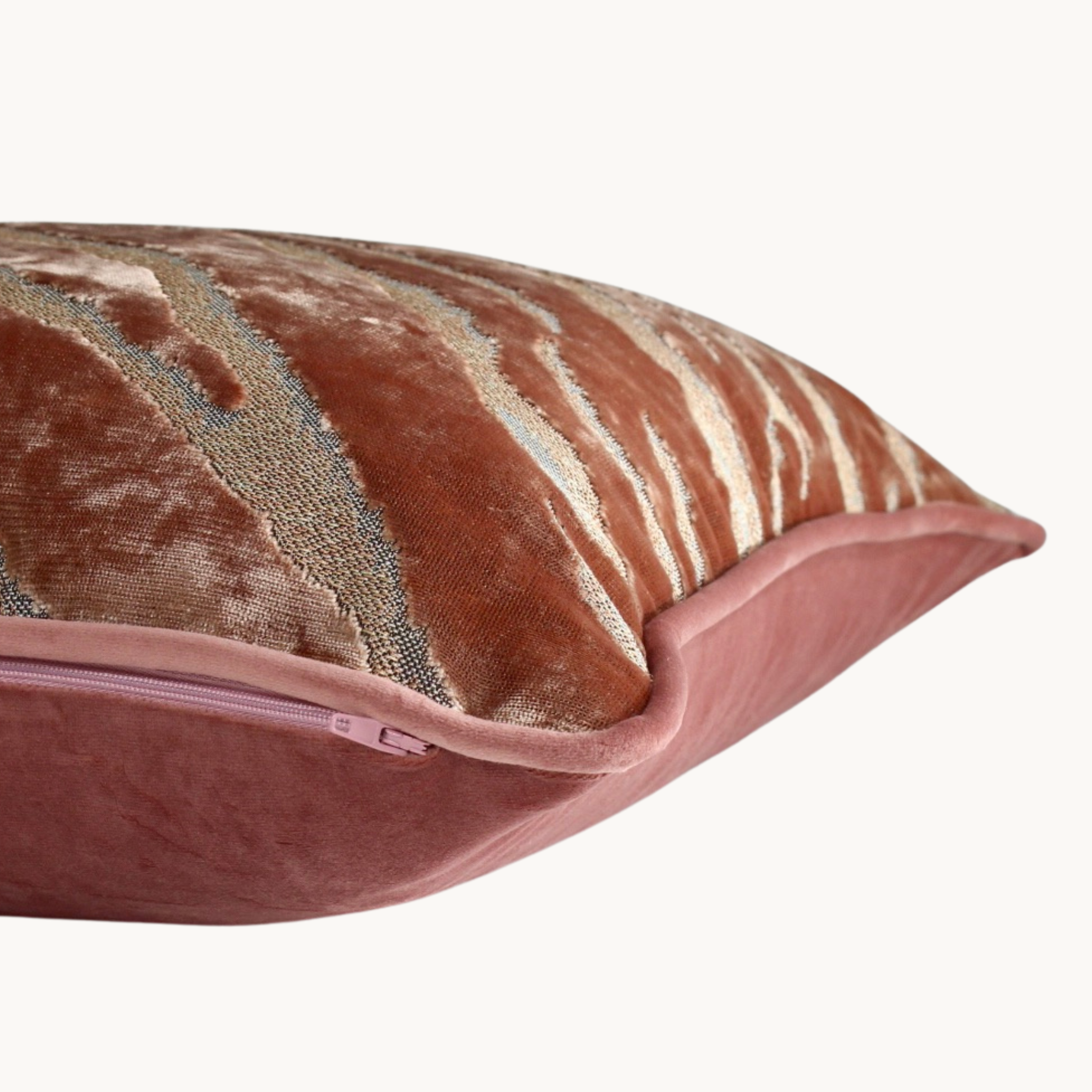 Side shot of a pink velvet cushion with a pink velvet piping