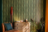 A rich green botanical wallpaper with wheat-like patterns, paired with a vintage dresser, wooden oars, and rustic décor