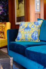Photo of a bright teal sofa with a yellow cushion
