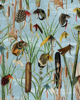 Image of fishing flies aquamarine wallpaper from Mind The Gap. This design features a detailed pattern of fishing flies and reeds in vibrant hues of green, orange, red and yellow, set against a light blue background. The finely illustrated flies evoke a vintage aesthetic.