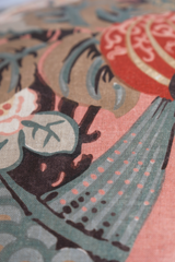 Close up of a floral linen with a large boquet of flowers in salmon, red, duck egg blue and rich brown.