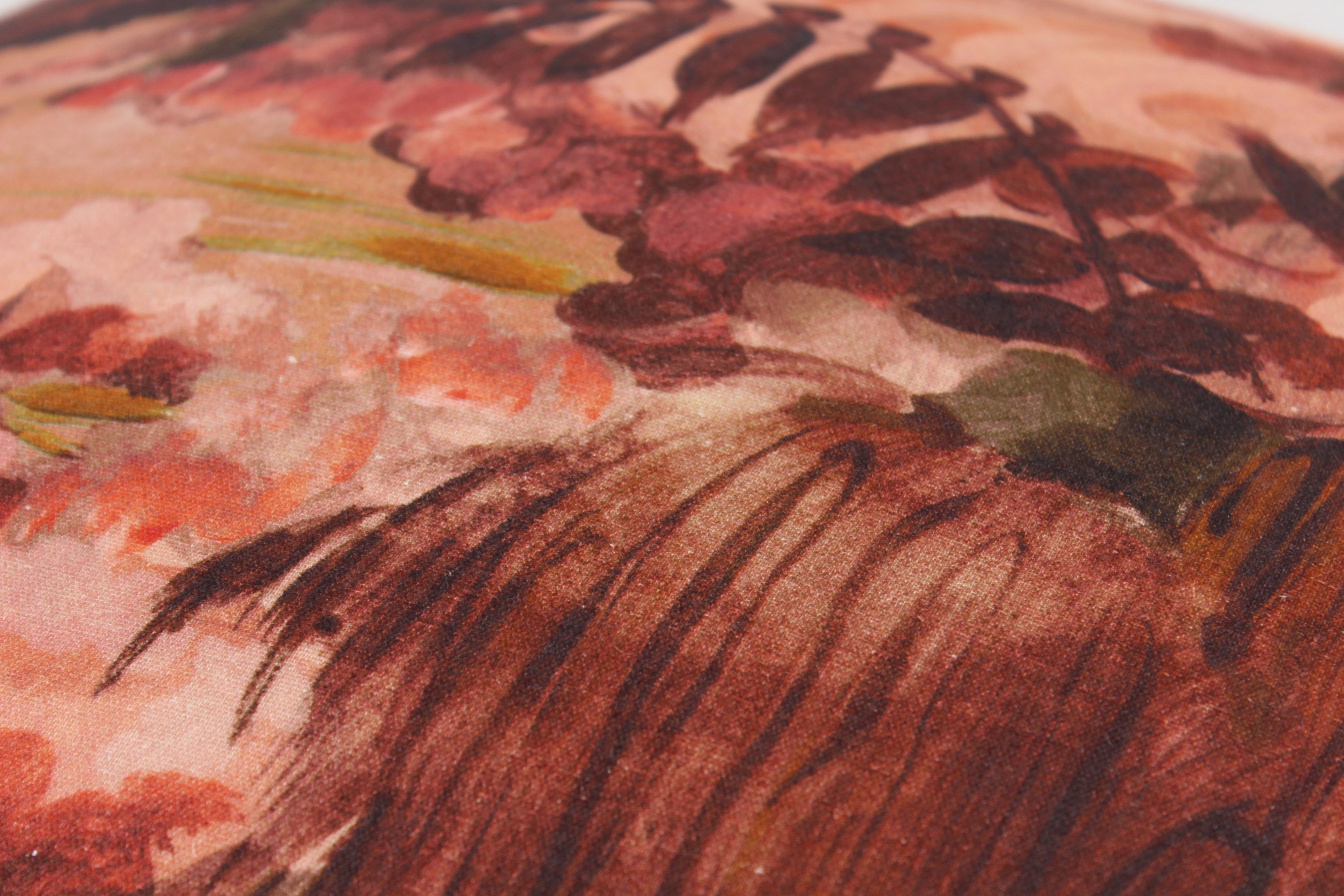 Close-up of a floral patterned fabric with red, green, and brown colors.