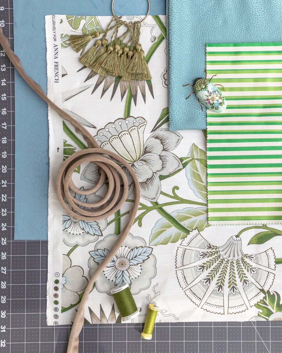 Fabric swatches with floral and striped patterns on a cutting mat.