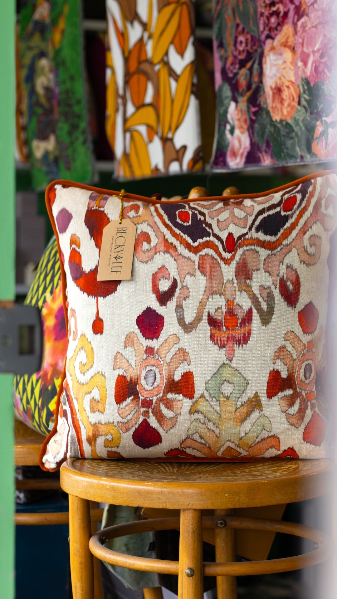 Decorative cushion with intricate ikat patterns on a wooden stool