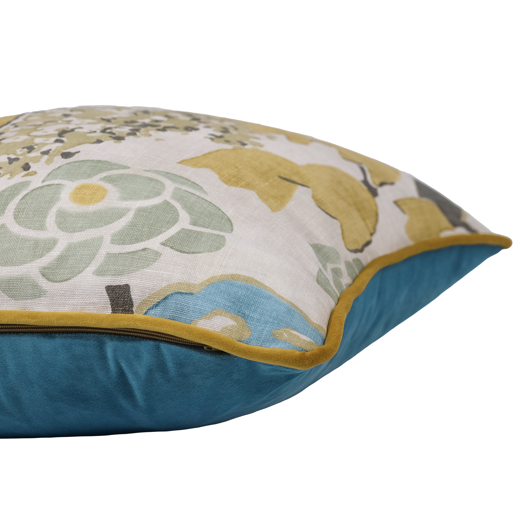 A close-up of a decorative throw pillow showing a floral patterned top with muted green, mustard yellow, and blue motifs on a light background, finished with a solid teal blue velvet-like bottom and a mustard yellow piped edge.