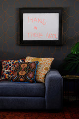 Lounge setting with wallpaper and a large sofa with colourful patterned cushions