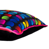 Side view of a neon bright cushion with rainbow of coloured beans on a black background