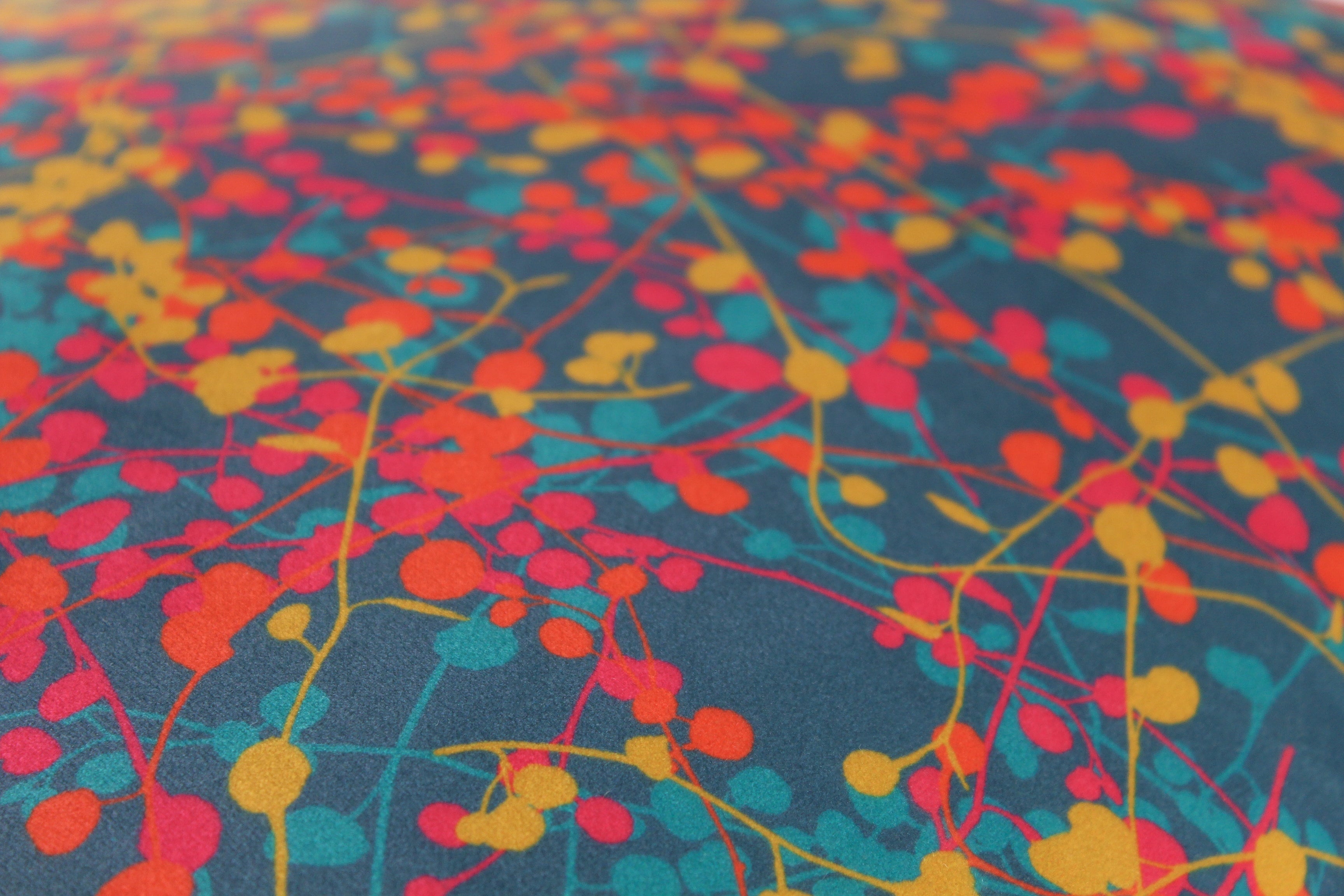Close up of a colourful velvet with fine vine leaves all over in bright colour