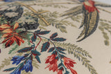 Close-up of a fabric with floral and bird pattern on a beige background