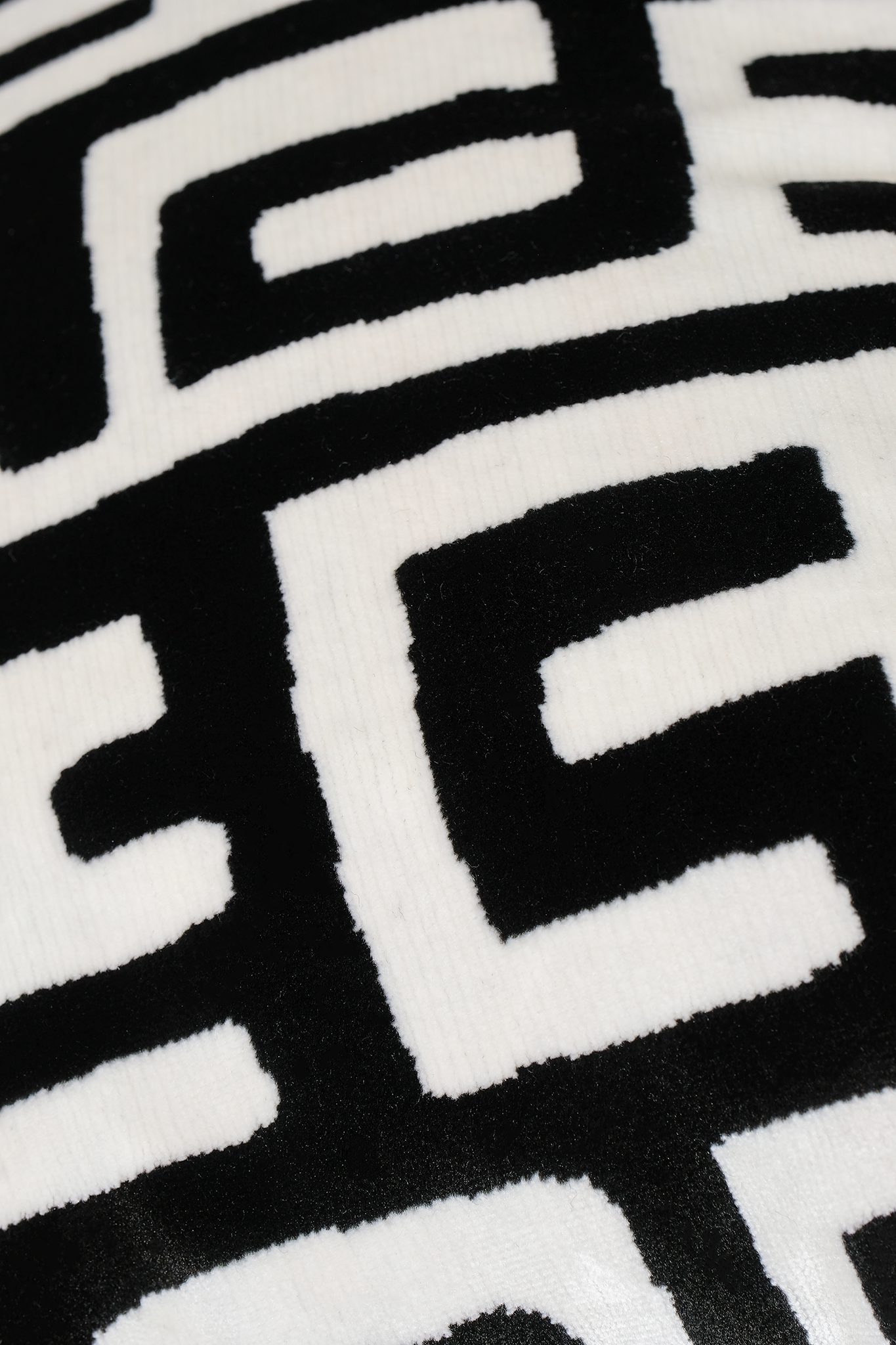 Close up of a black and white labyrinth patterned velvet