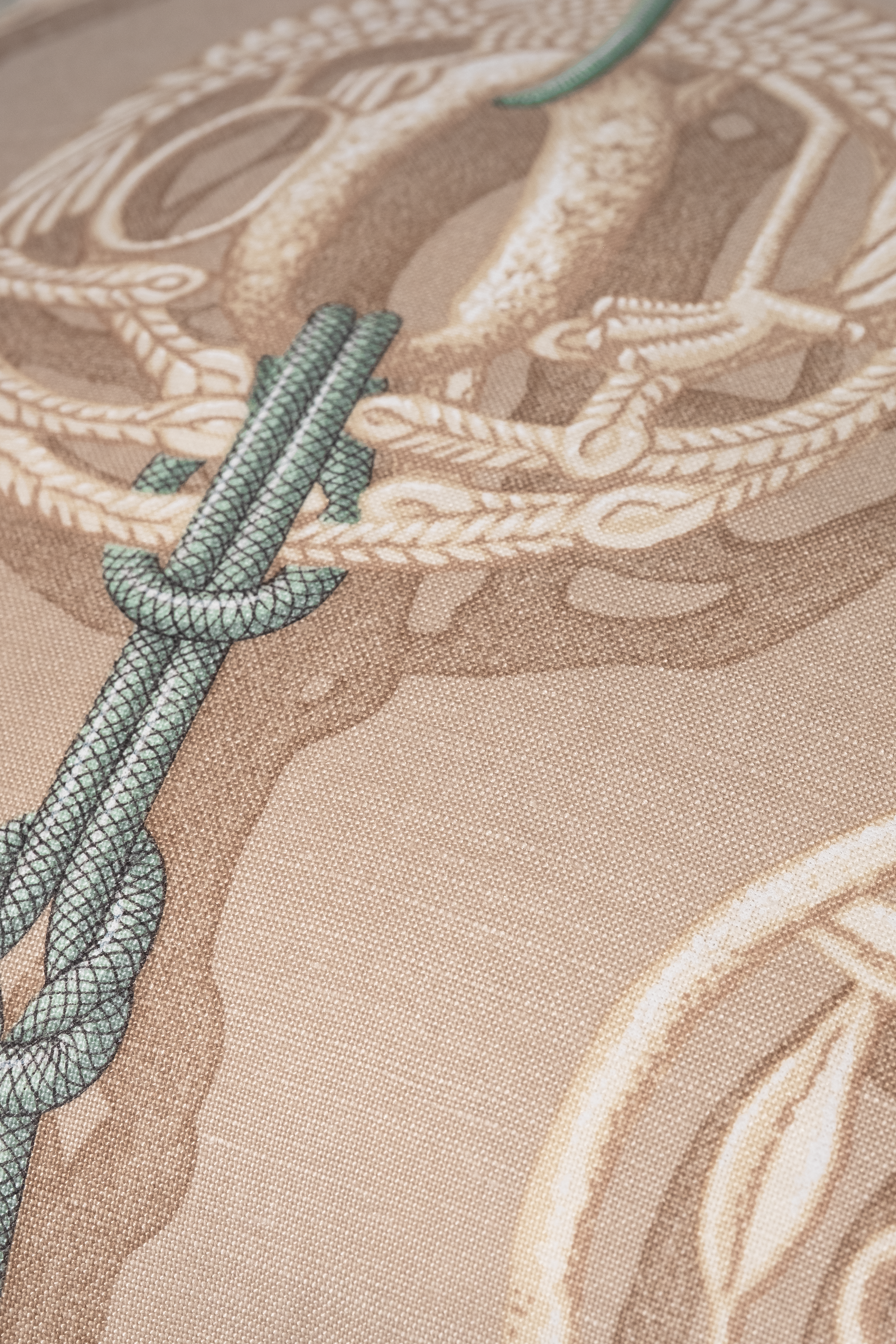Close up of a printed cotton with a carved medallion and braided cord.