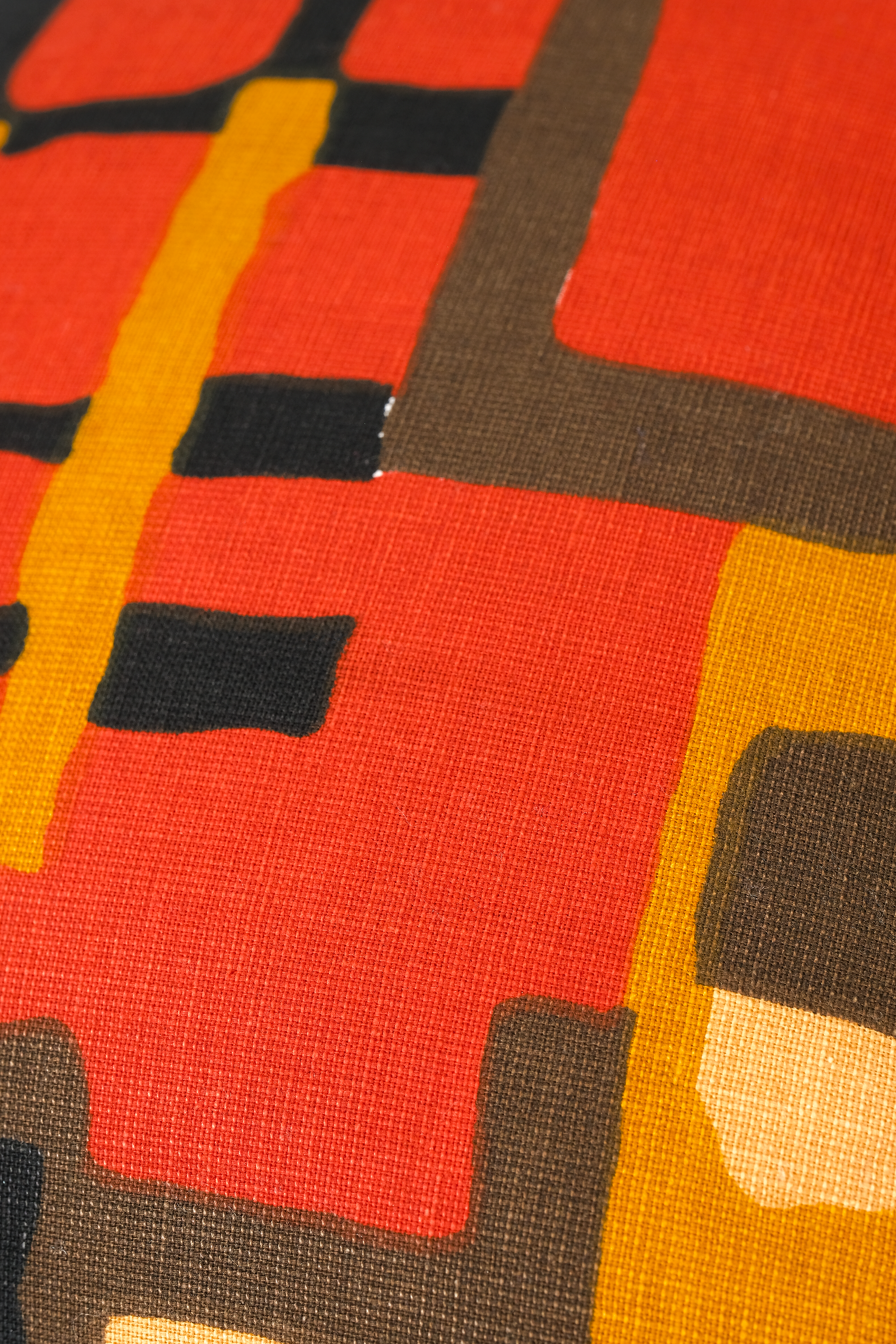 Close-up of a fabric with red, yellow, and black geometric pattern