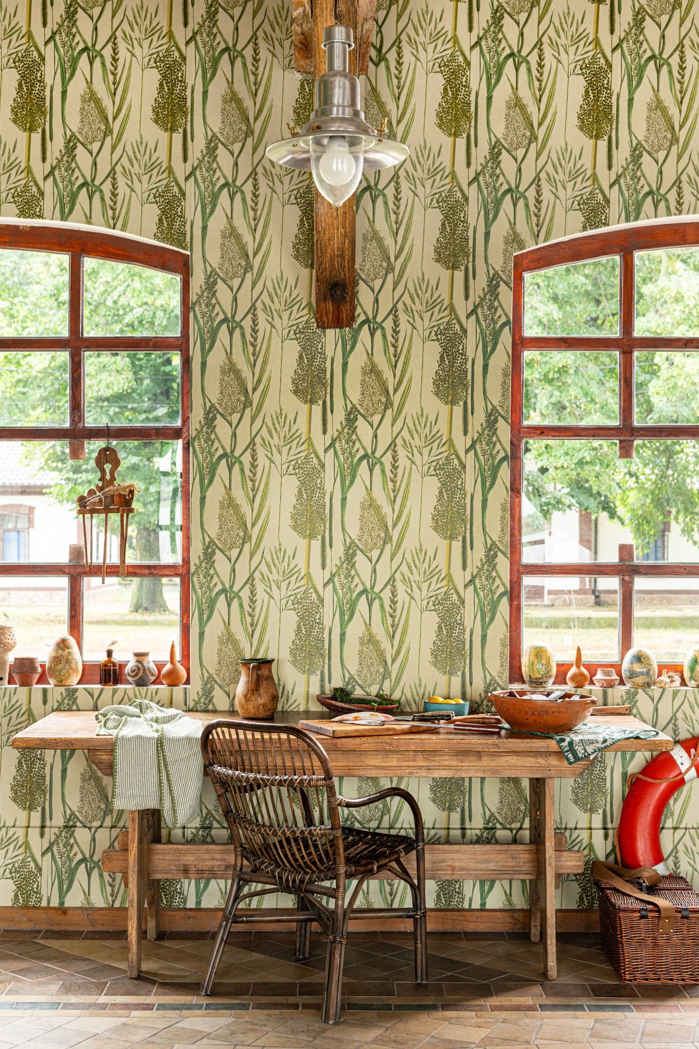A nature-inspired wallpaper with green botanical motifs, styled in a rustic dining space with wooden furniture and earthy décor