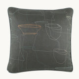 Photo of a very muted cushion with a grey linen basecloth and outlines of finely drawn mid century ceramics.
