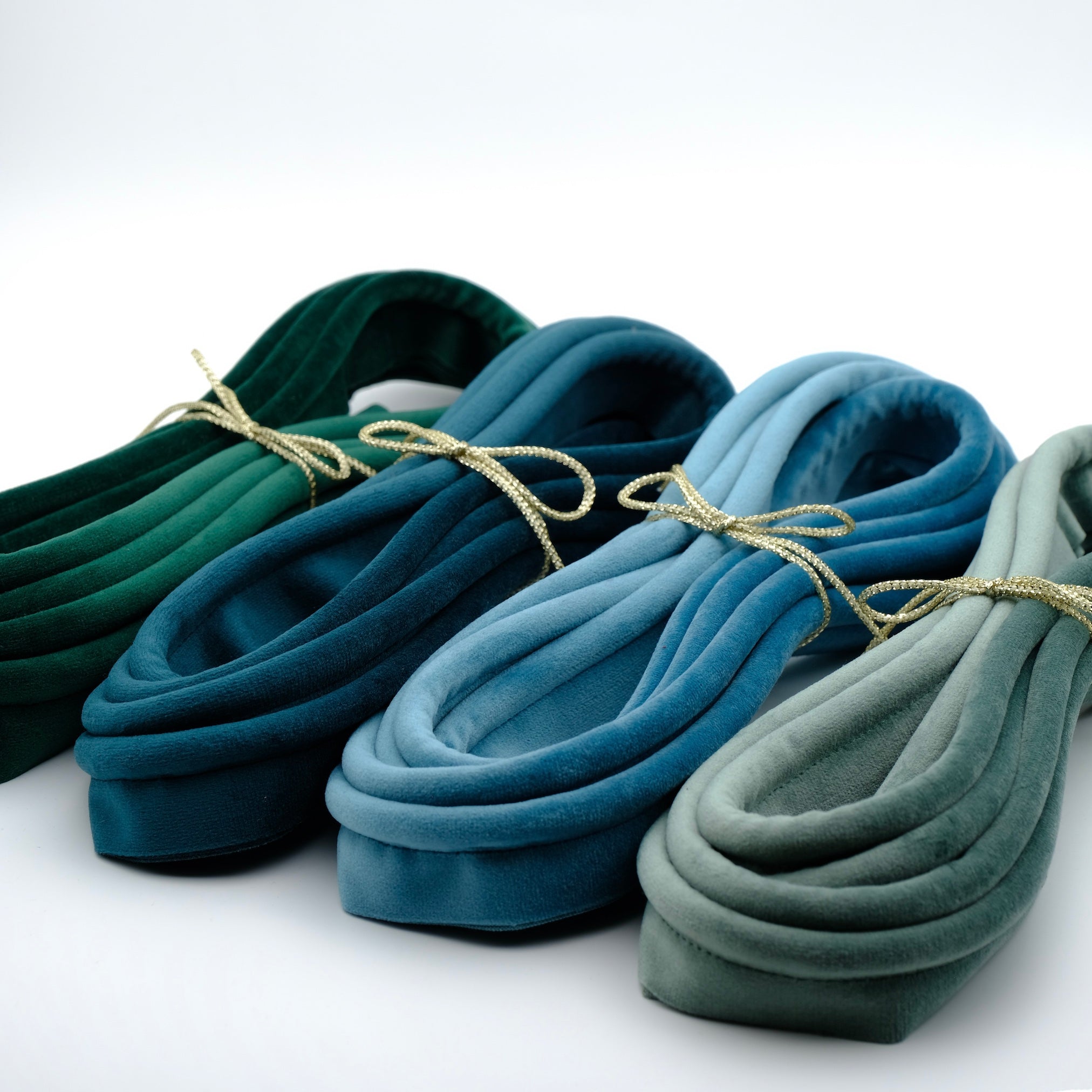 photo of a group of four bundles of velvet piping in blue and blue green tones