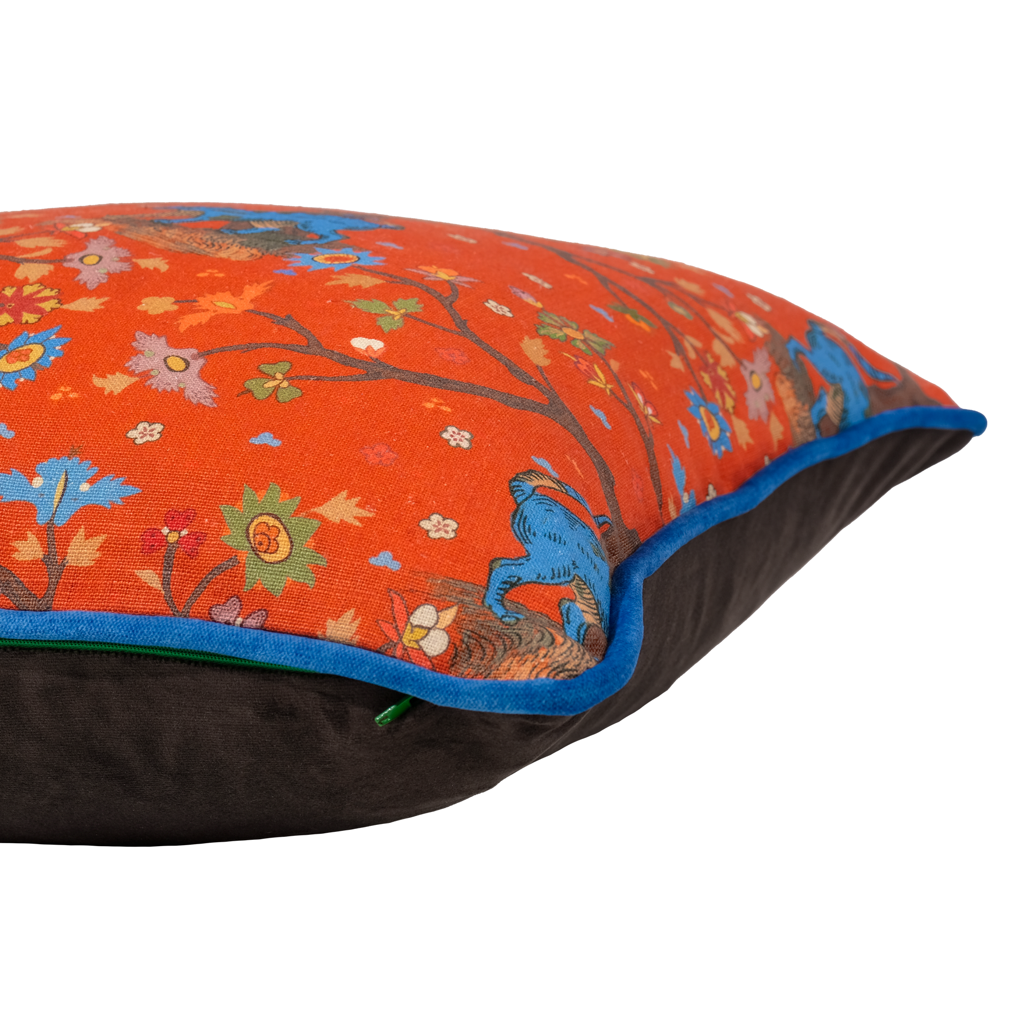 A square decorative throw pillow with a vibrant orange floral and bird patterned top half, a dark brown bottom half, and a bright blue piping trim.