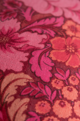 Close-up of a floral fabric pattern with pink and red colors.