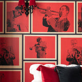 Red wallpaper featuring vintage-style black and white jazz musician portraits in a grid pattern, shown behind a white sofa with red and black cushions.