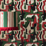 A green, red and black abstract wallpaper with overlapping silhouette faces and geometric shapes, creating a bold statement wall.