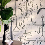 Hand-drawn mural wallpaper of a jazz band performing under palm trees, next to a fiddle-leaf fig plant.
