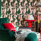 Living room with green armchair, red cushion, and wallpaper of green and red silhouettes of jazz musicians.