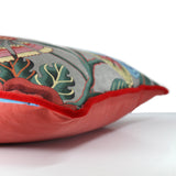 Side view of a floral linen cushion - grey background, red, pink and blue stylised flowers with red velvet piping