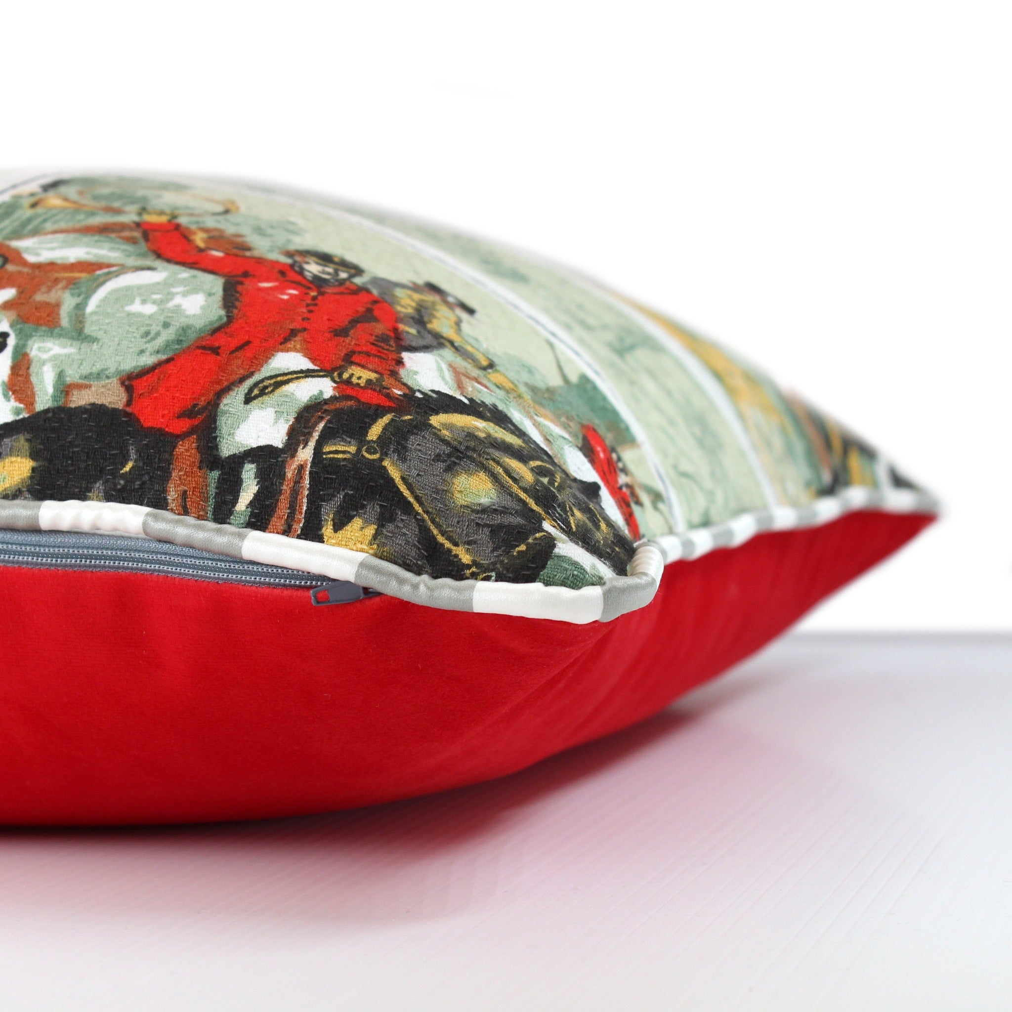 Side view of a vintage barkcloth cushion with a classic english hunting scene of a huntsman on his horse with hounds at his feet, crisp grey and white piping and a scarlet velvet back