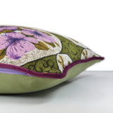 Side view of a cushion made from a vintage barkcloth in a sweet floral design with medallions of lilac flowers and an olive green background with grape velvet piping
