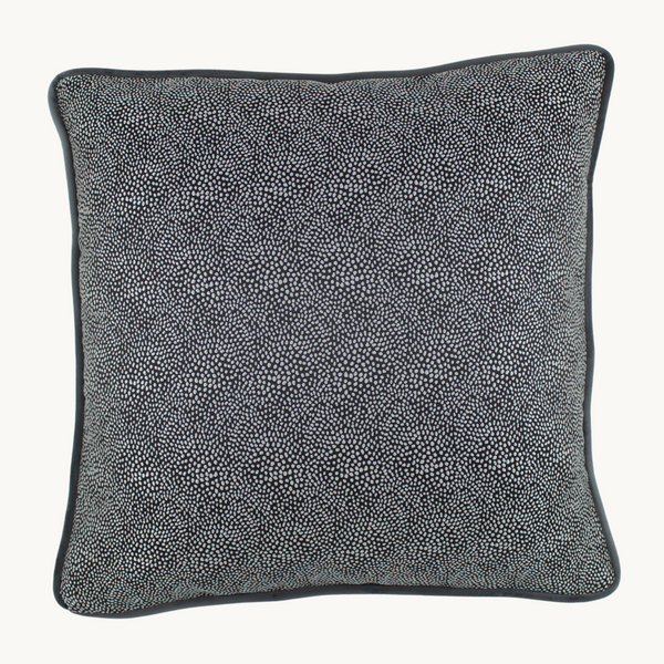 Photo of an achromatic cushion with a subtle black spot on the front.