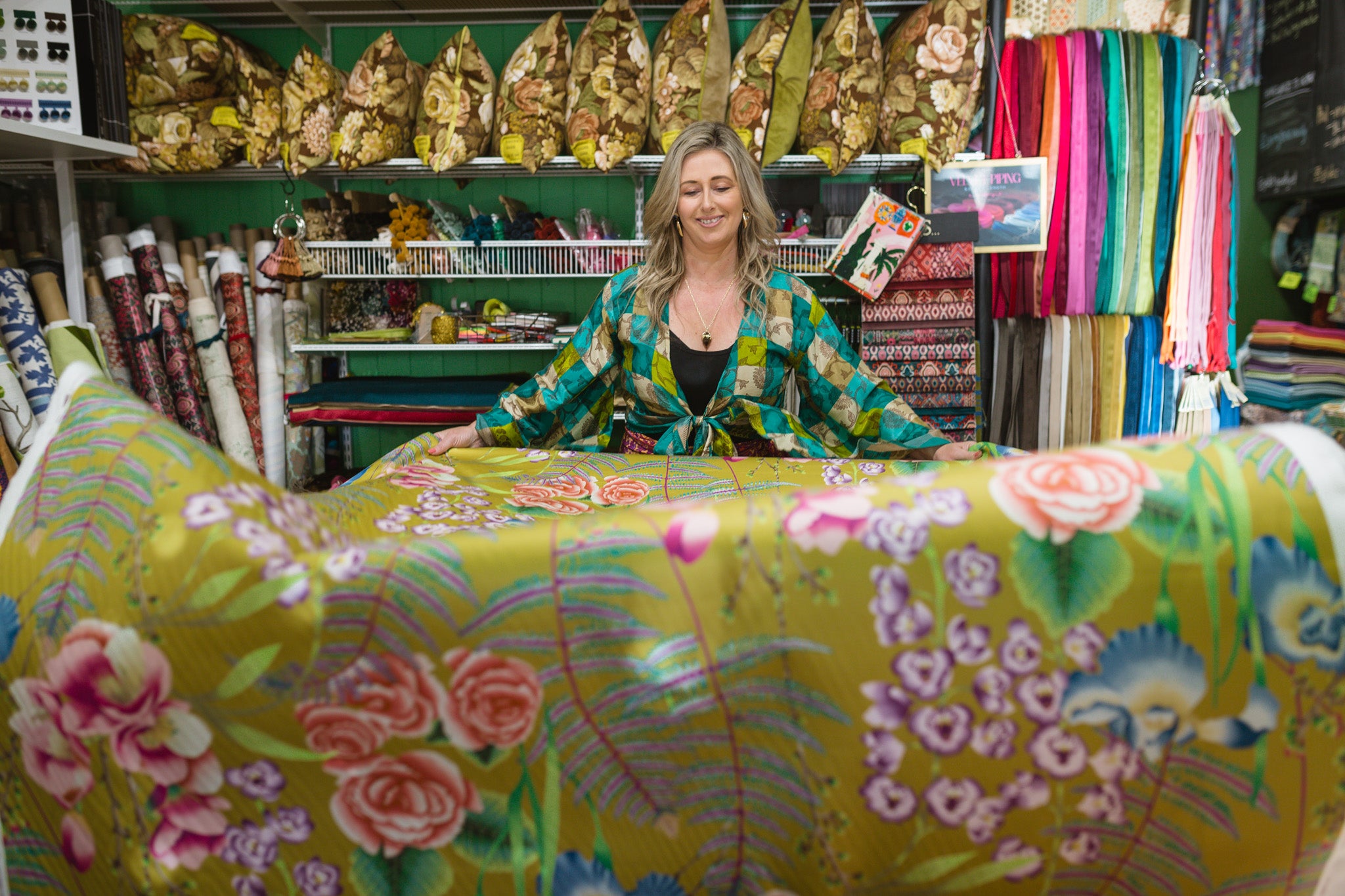 Woman working with some floral fabric in a cushion workroom