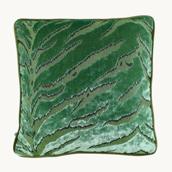 Photo of a cushion in a soft green cut velvet with an animal print inspired design