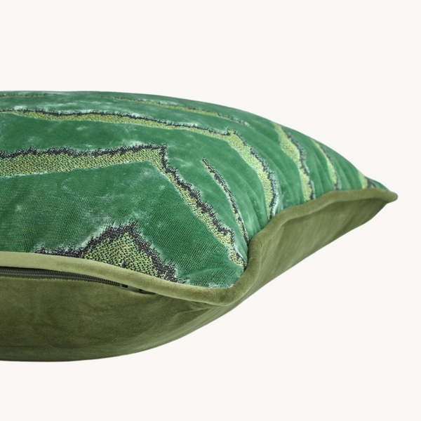 Side shot of a piped cushion in a soft green animal print velvet