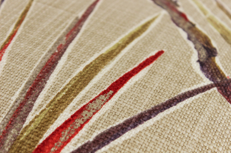 Close-up of fabric with red, brown, and beige large scale strappy leaves pattern