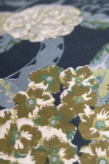 Close-up of a floral fabric pattern with green, white, and blue colors.