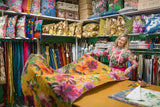 Woman in a fabric store with colorful fabrics and materials around her