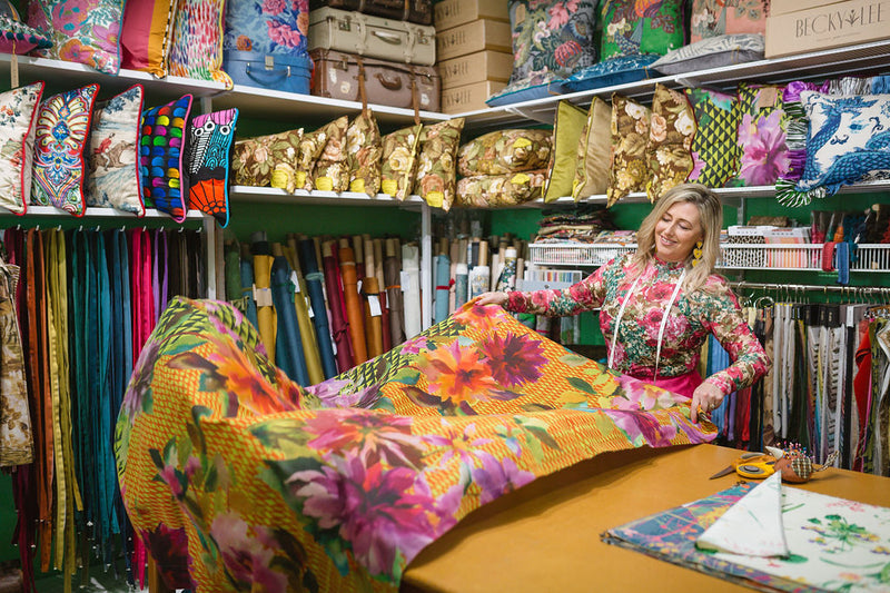 Woman in a fabric store with colorful fabrics and materials around her