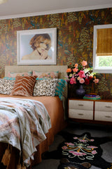 Bedroom with a floral arrangement, peacock wallpaper and lots of decirative elements