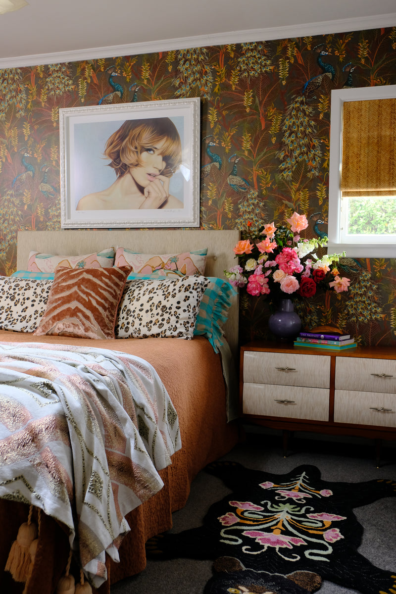 Bedroom with a floral arrangement, peacock wallpaper and lots of decirative elements