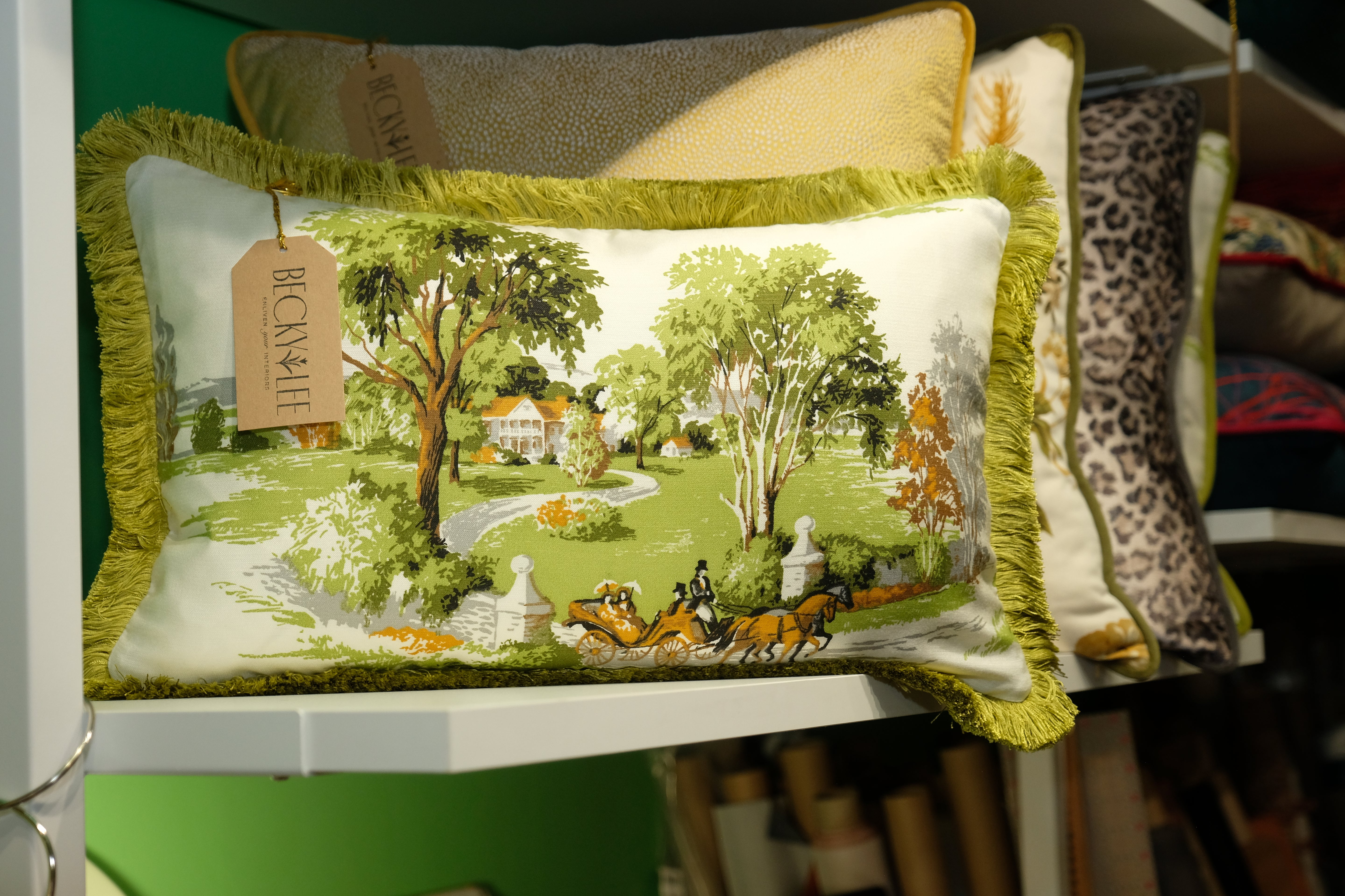 Decorative pillow with a scenic design on a shelf