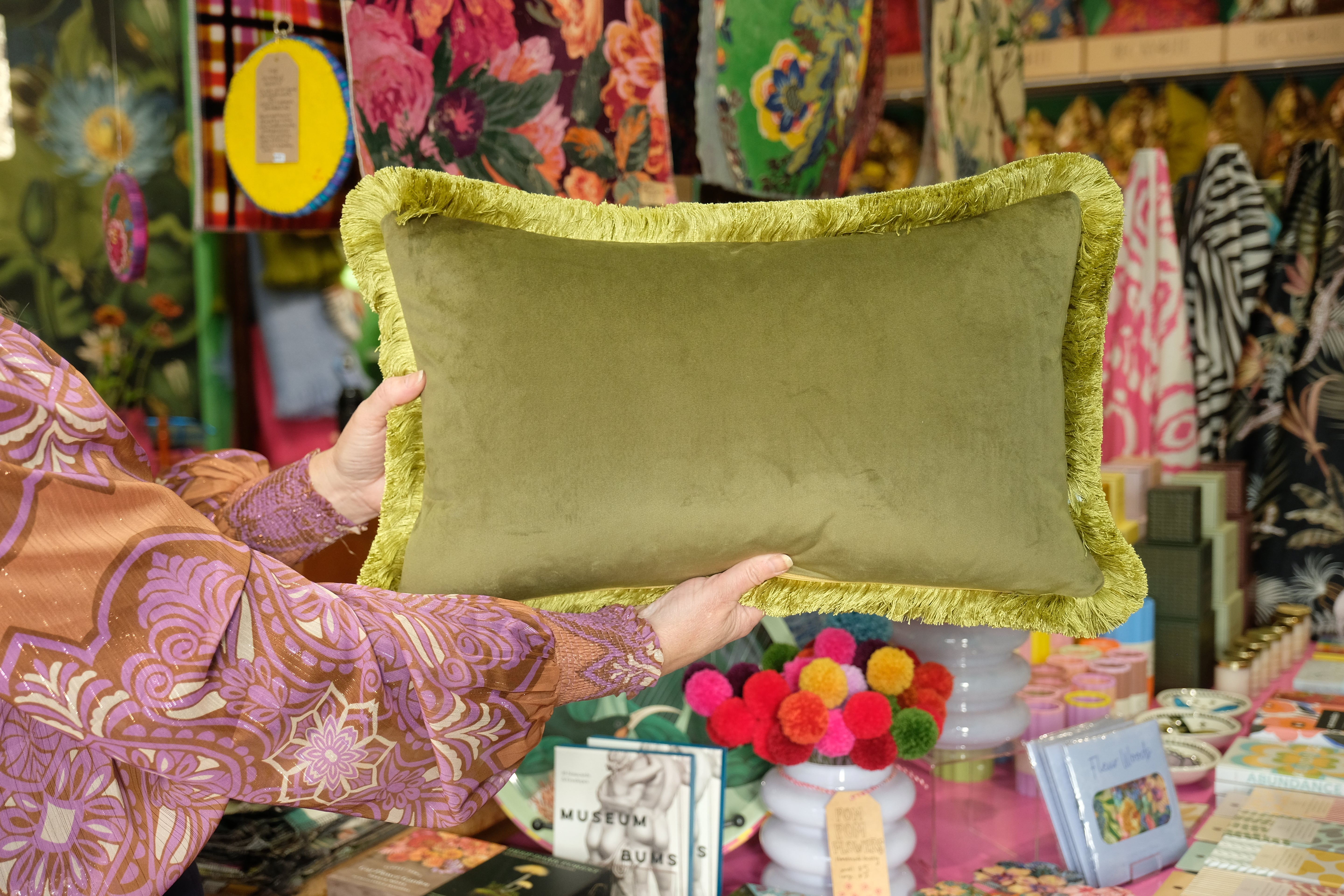 Person holding a green pillow with colorful background