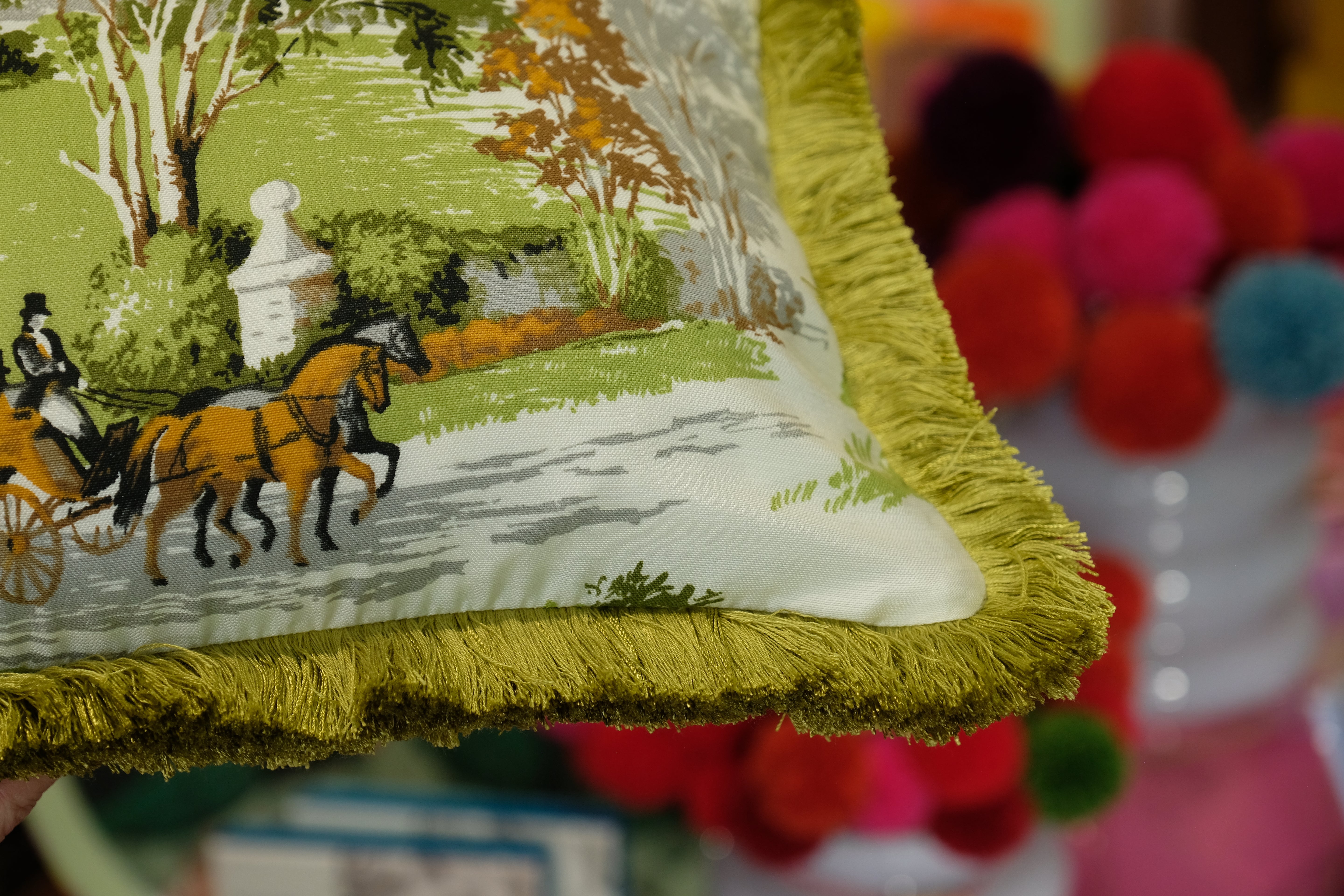 Decorative pillow with horse and carriage design on a colorful background