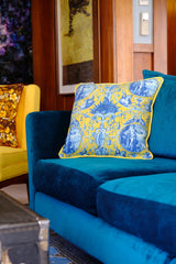 Photo of a bright  teal sofa with a yellow cushion