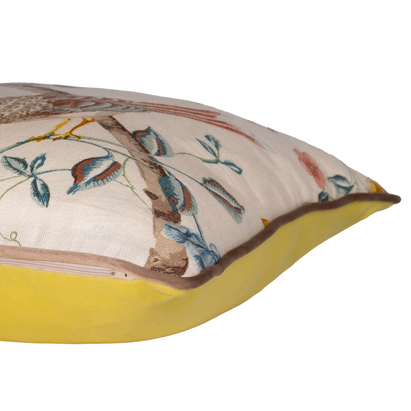 Side view of a decorative cushion with floral and bird design on a linen background