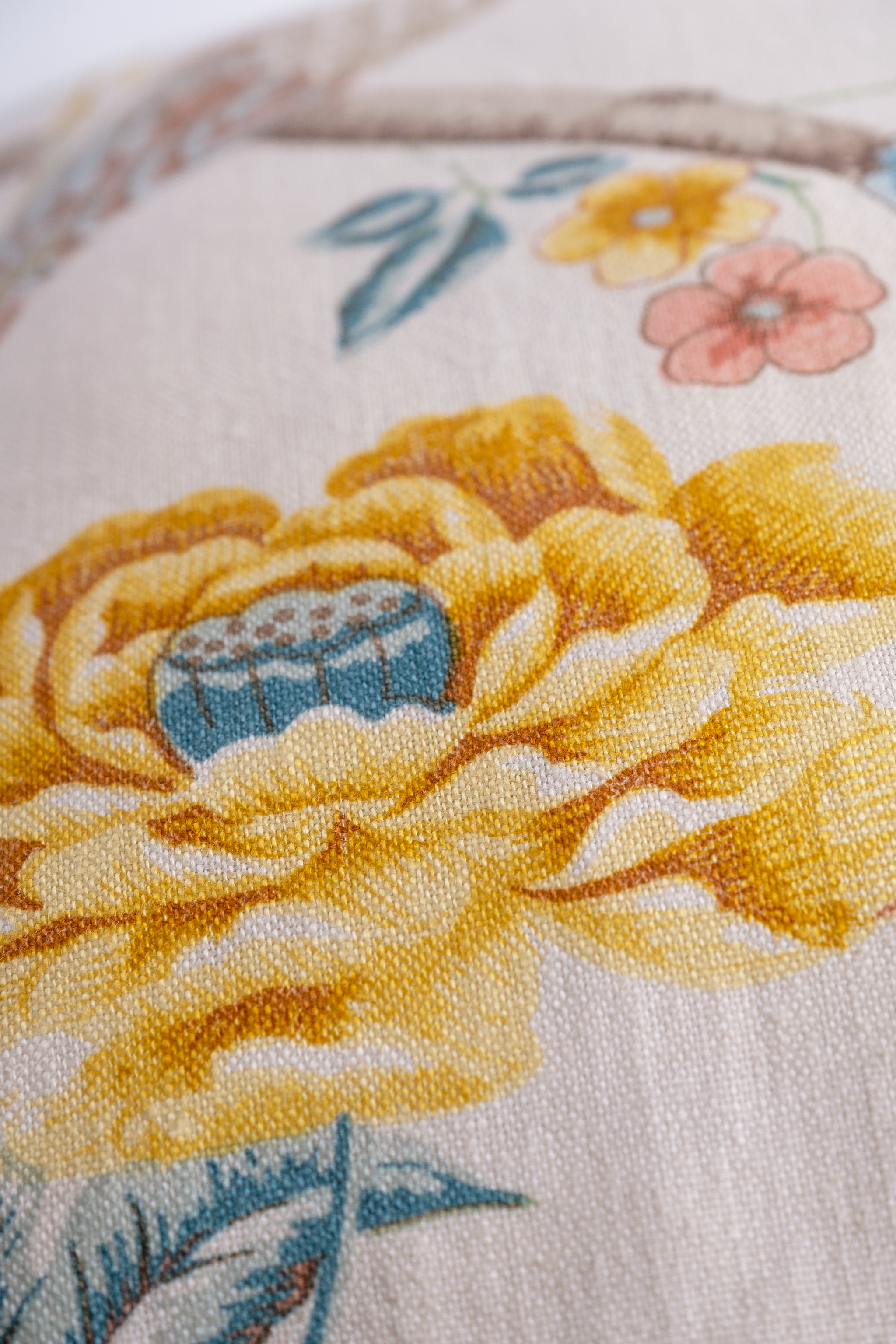 Close-up of a floral pattern with yellow flowers and blue centers on a white background.