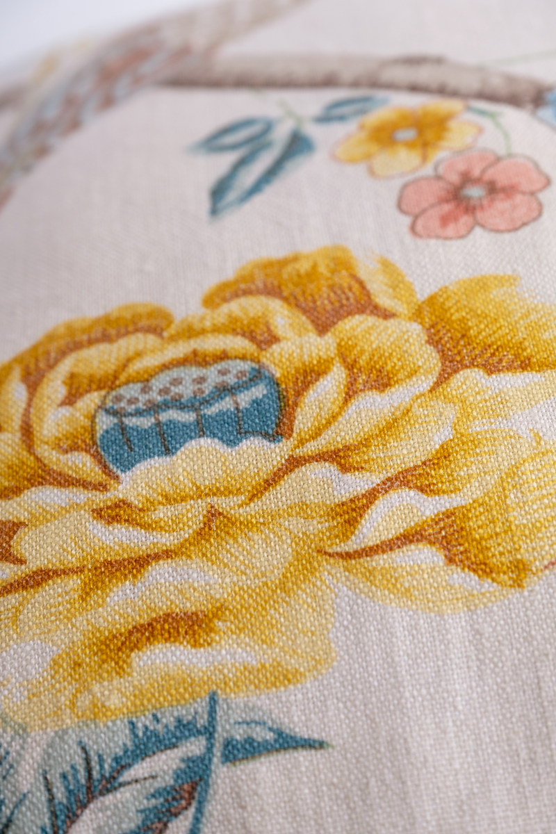 Close-up of a floral pattern with yellow flowers and blue centers on a white background.